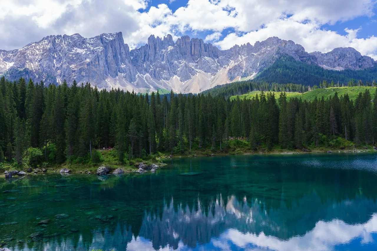 Bosque alpino reflejado en un lago en los Dolomitas, ejemplo de los ecosistemas europeos afectados por el cambio climático