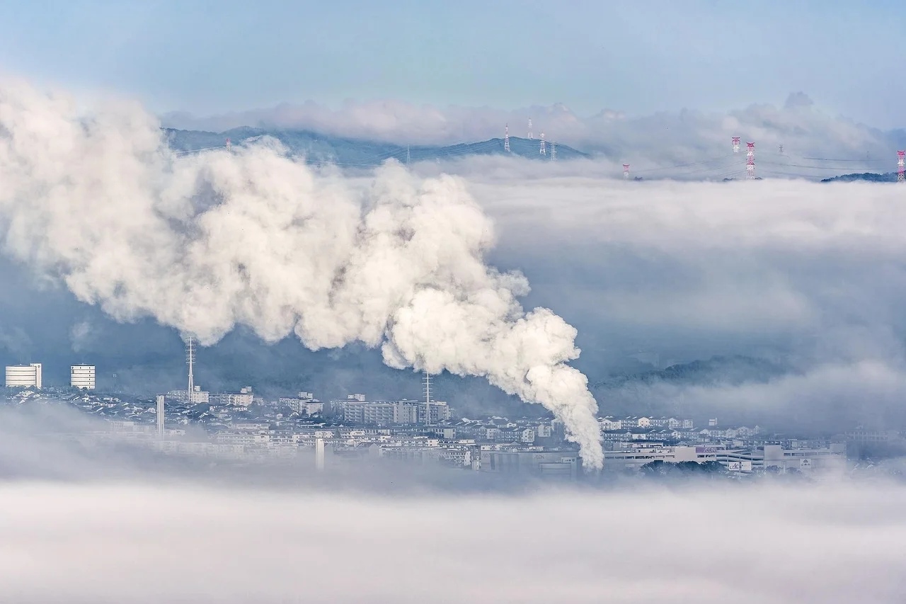 Una nube espesa de humo blanco sale de una instalación industrial